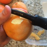 Peeling the grapefruit in long, wide pieces